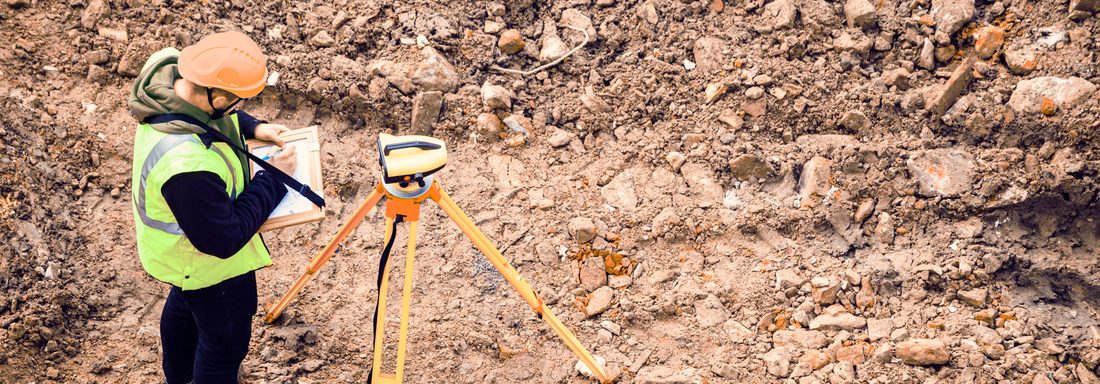Surveyor with total station on site